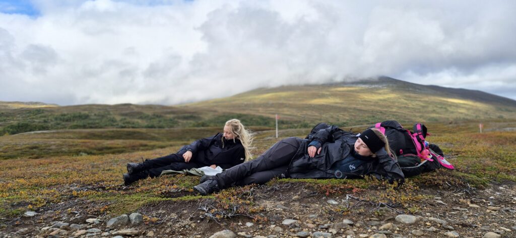 Deltagare tar paus under fjällvandring